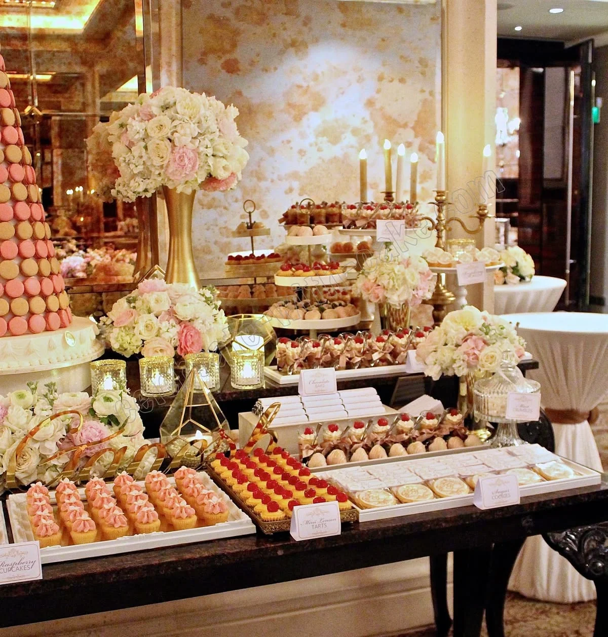 Mesa de postres lujosa con macarons y arreglos florales