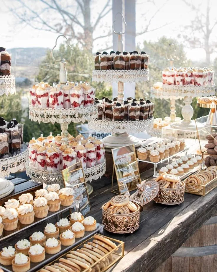 Mesa de postres completa con diferentes dulces y alturas