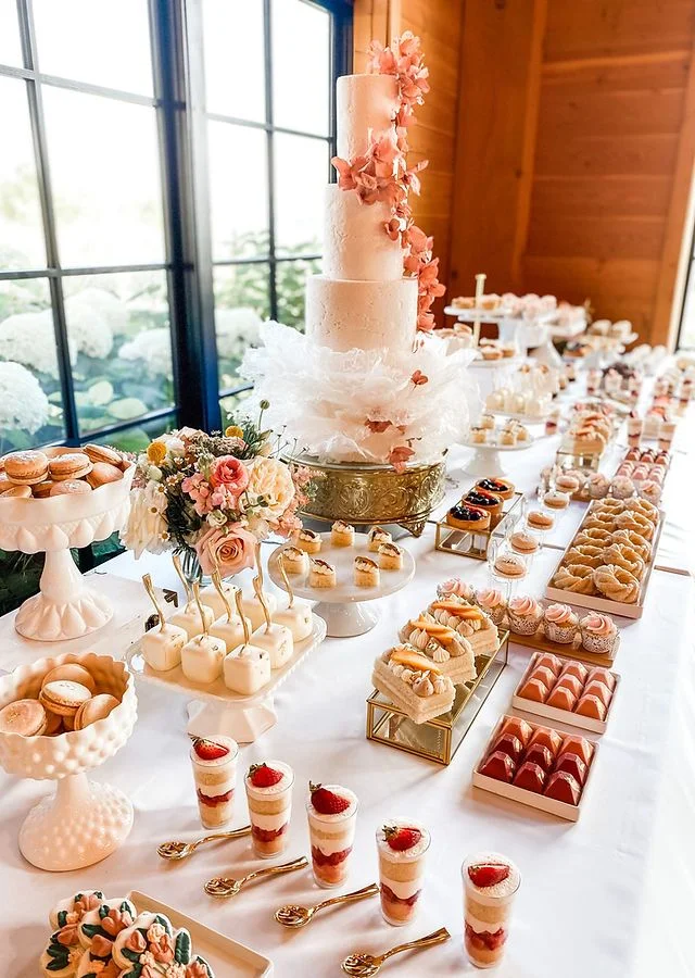 Mesa de postres decorada con pastel, cupcakes y macarons