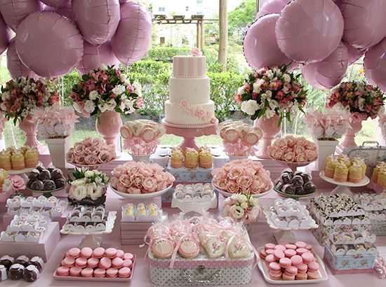 Emprendedora montando una mesa de postres de cumpleaños en rosa y dorado